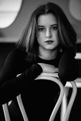 Black and white portrait of a young beautiful dark-haired girl in a low key.