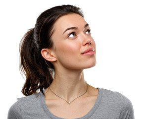 Fototapeta premium Woman looking up thoughtfully: A young woman with brown hair tied back in a ponytail gazes upward, lost in thought or contemplation. Her expression is serene and hopeful.