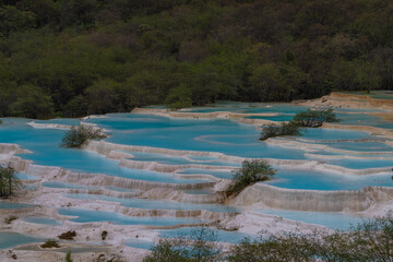 Huanglong National Park, blue water in limestone wells is a landmark for tourists to visit in Ngawa Tibetan and Qiang in Sichuan, China : June 18r 2024