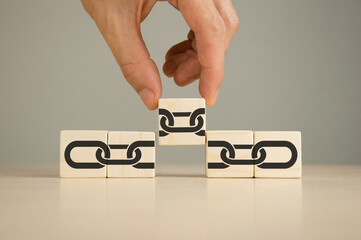 Businessman puts wooden cubes with chain links