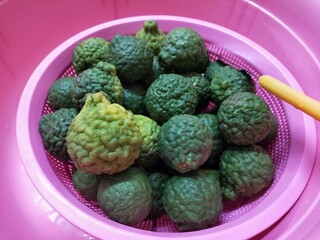 Fresh kaffir lime in pink plastic basket