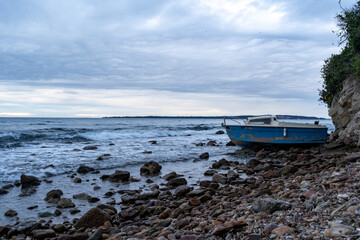 Boat at sunset, waves on the sea. High quality photo.