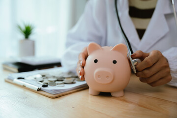 Doctor using stethoscope to examine a piggy bank, symbolizing the savings in medical care and...