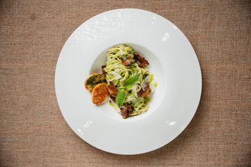 Pesto Pasta Dish Overhead View of Green Pasta with Toasted Bread on White Plate