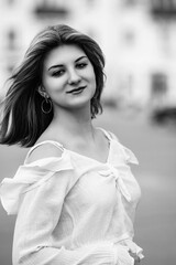 Black and white portrait of a young beautiful long-haired girl outdoors.