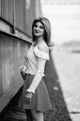 Black and white portrait of a young beautiful long-haired girl outdoors.