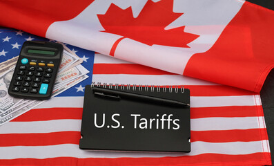 Notepad with the inscription “US Tariffs” and American and Canadian flags.