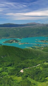 Vertical aerial view of Rama Lake, a beautiful and breathtaking lake with many small islands. It is truly a stunning sight, surrounded by lush green mountain slopes. Bosnia and Herzegovina. 