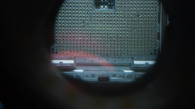Close-up of a computer CPU socket under magnification, revealing potential structural damage or bent pins during technical examination.