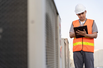 Asian maintenance engineer works on the roof of factory. contractor inspect compressor system and...
