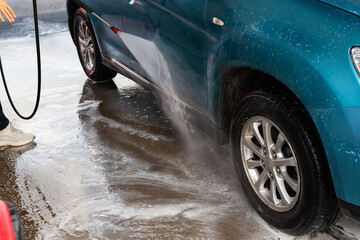 Woman washing her car in a self-service car wash station.Car wash self-service.