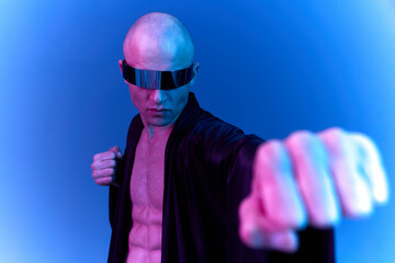 Powerful man in black robe, showcasing strength in a blue neon light setting, representing...
