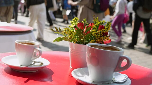 Two cups of coffee with flowers on table at outdoor Paris cafe