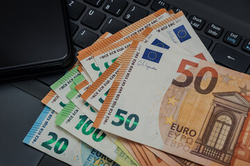 Notebook, Smartphone und Eurogeldscheine