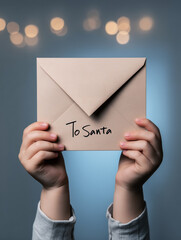 child’s hands holding a glittery, sparkly letter to Santa 