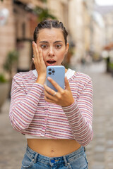 Upset young woman using smartphone typing browsing loses becoming shock sudden lottery results bad...