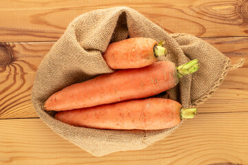Organic carrots on a wooden table, macro, top view.