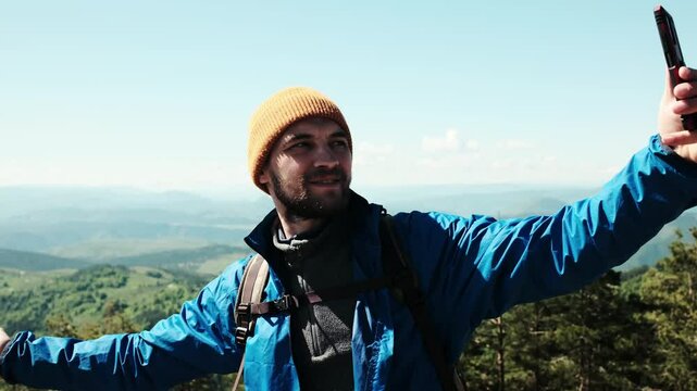 Happy tourist stretching arms wide for a selfie, enjoying the scenic view from Tornik peak. Serbia country during spring. Travel blogger making video outdoor. Horizontal 4k footage
