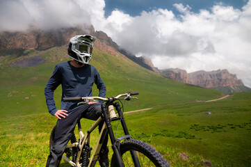 Cyclist man resting sitting on bicycle outdoors. Portrait of athlete man, rider in helmet and...