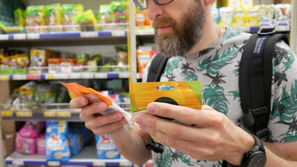 A male customer choosing animal food in a pet shop