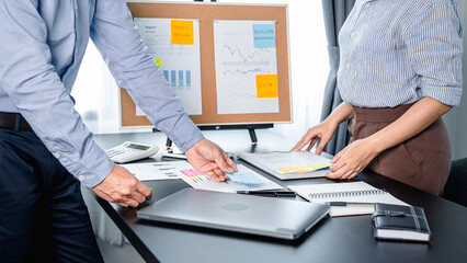 Two business colleagues looking word in sticky note and putting post it notes to share idea on document