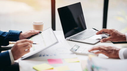 Two people are working on a project together, with one person using a laptop