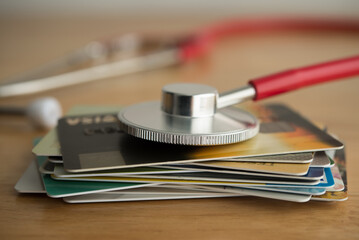 Close up red stethoscope on many credit card. Past due payment or least minimum for credit card,...