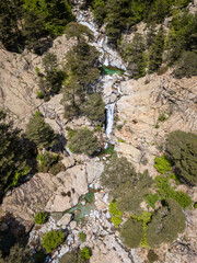 Aerial view of the Cascade des Anglais on the L'Agnone river flowing through the forest and mountains along the GR20 trail at Vizzavona on the Mediterranean island of Corsica
