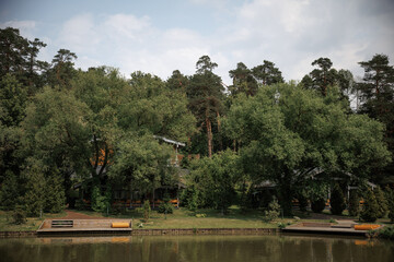 Peaceful lakeside scene with charming cottages nestled among lush greenery. The tranquil setting...
