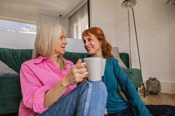 Two senior women relaxing and drinking tea at home
