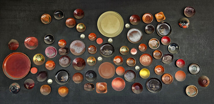 Group of colorful dish or plade on black wooden background. Art of object or disware decorated on board.