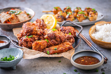 Fototapeta premium Assortment of Asian street food, stir fry with vegetables, chicken wings, meat balls and rice