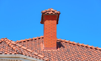 house with a roof from a red shingles with a pipe