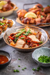 Assortment of Asian street food, stir fry with vegetables, chicken wings, meat balls and rice
