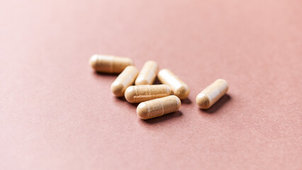 Reishi capsules. Concept for a healthy dietary supplementation. Paper background. Soft focus. Close up.	