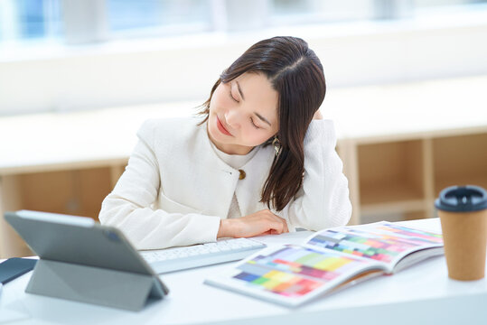 パソコン作業をしながら疲れた表情の女性