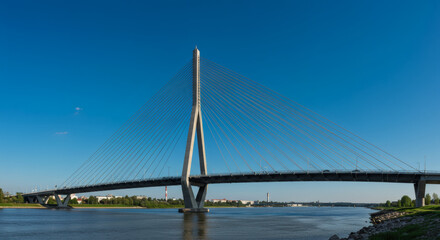 Fototapeta premium Majestic Cable-Stayed Bridge Stunning Architecture and Buildings Across the River