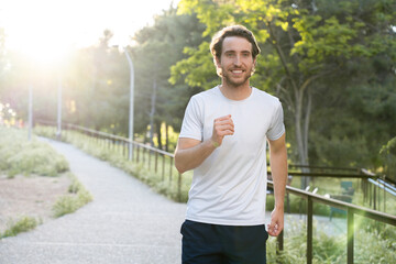 Man practicing running in the city park on a sunny afternoon