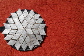 Kaju katli Indian sweets background with silver varak foil. Top view of Kaju katli made of...