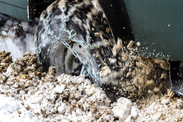 Close-up. The wheel of a car digging into deep snow.  Capturing the movement and energy while...
