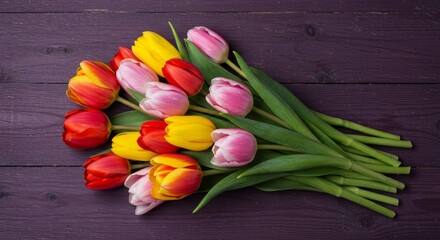 Vibrant Spring Tulip Bouquet - A colorful arrangement of tulips in shades of red, yellow, and pink rests on a dark wooden surface