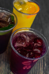a set of colorful summer cocktails with berries, mint leaves and ice cubes on a gray background. summer menu for coffee shops and cafes