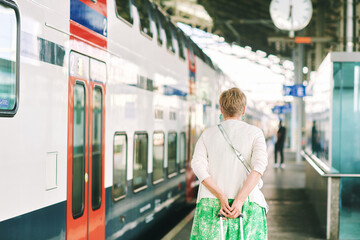 Outdoor portrait of 55 - 60 year old woman at the train station, vacation and active lifestyle