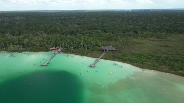 Aerial view of the stunning Laguna Kaan Luum, a hidden gem near Tulum, with tourists swimming and relaxing in its turquoise waters