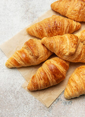 Freshly baked croissants with wheat on baking paper