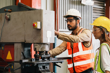 Working in a factory with modern industrial machines, engineers operate equipment with precision...
