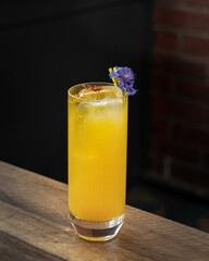 Fancy clarified yellow colour cocktail with clear ice in a fancy glass