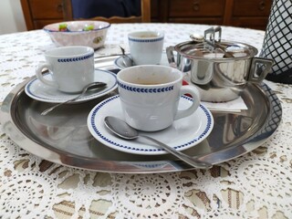 Сups of coffee with saucer and teapot on table at home, close-up. traditional italian morning coffee on a beautiful set table.