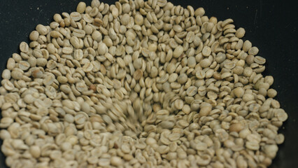 Green coffee beans rotating in a roasting machine