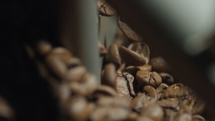 Roasted coffee beans falling and creating a small